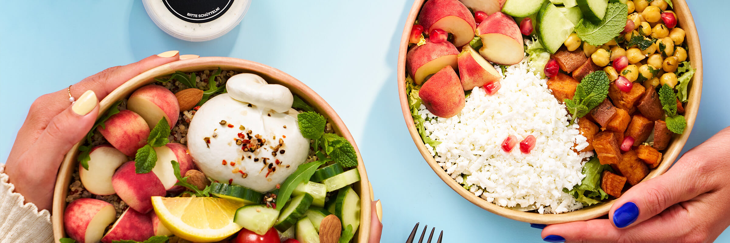 Drei Salatschüsseln mit verschiedenen frischen Zutaten liegen auf einer gestrickten Unterlage. Die Schüsseln sind mit einer Vielzahl von Zutaten gefüllt, darunter Kichererbsen, Süßkartoffeln, Feta-Käse, Birnen, Rote Bete, Tomaten und Salat. Eine Hand hält einen kleinen Behälter mit Dressing. Das Bild ist hell und farbenfroh, zeigt gesunde Zutaten und eine köstliche Mahlzeit.
